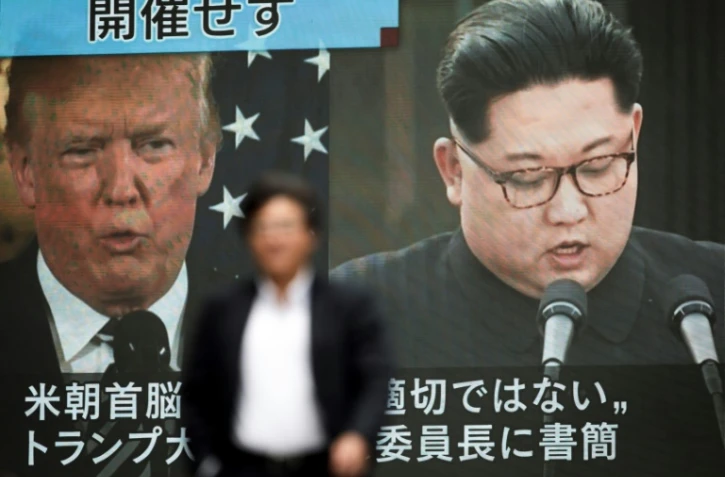 Les images du président américain Donald Trump (g) et du leader nord-coréen Kim Jong Un sur un écran géant dans une rue de Tokyo, le 25 mai 2018 au Japon
