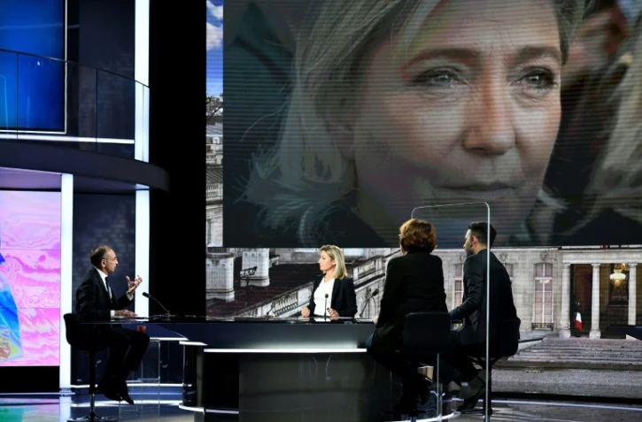 Le candidat Reconquëte! à la présidentielle française Eric Zemmour (g) sur le plateau de France 2 et son adversaire du RN Marine Le Pen (sur l'écran) à Paris, le 1er février 2022