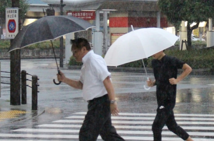 Des piétons sous la pluie à Tokushima au Japon, le 23 août 2018