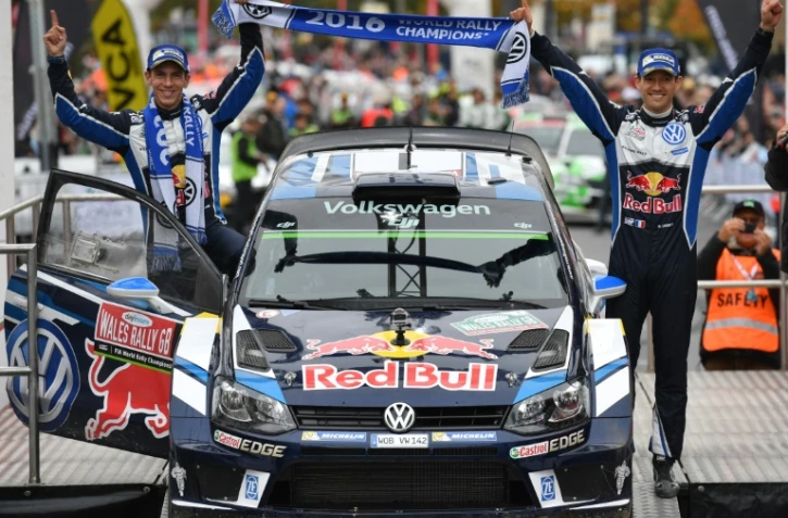 Sébastien Ogier (d) et son copilote Julien Ingrassia posent à côté de leur Polo VW après avoir remporté le Rallye de Grande-Bretagne, le 30 octobre 2016 à Llandudno au pays de Gallles 