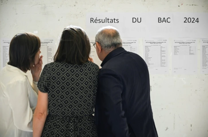 Des professeurs consultent les résultats du baccalauréat dans le hall du lycée Claude-Bernard, le 8 juillet 2024 à Paris