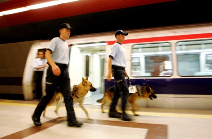Deux policiers turques marchent avec leurs chiens dans le métro d'Istanbul, le 11 juillet 2005 