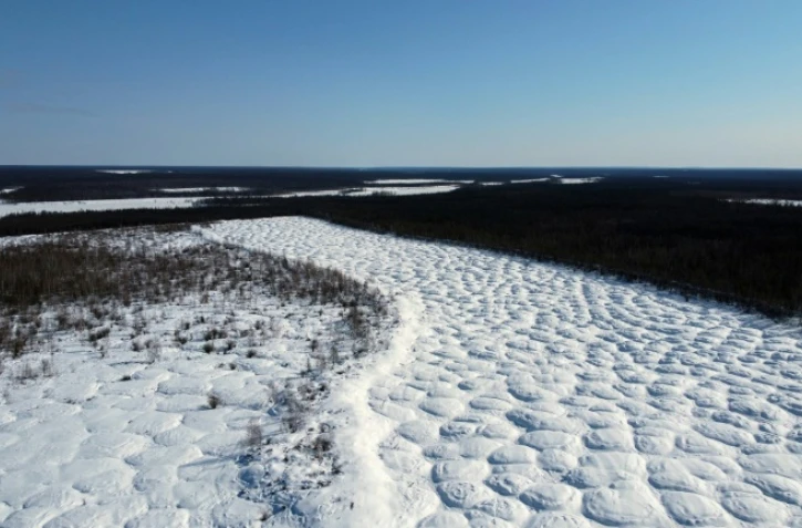 Vue aérienne de champs tapissés de bosses formées par le dégel du pergélisol, connues sous le nom de "bylars" en langue iakoute, près du bourg de Tchouraptcha, à environ 135 kilomètres de Iakoutsk, en Sibérie orientale, le 29 mars 2025