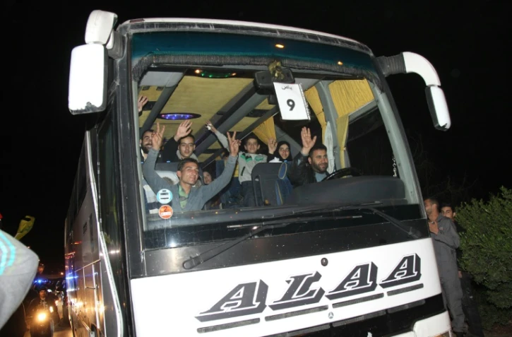 Des bus transportant des Syriens évacués de Fuua et Kefraya transitent par Beyrouth le 29 décembre 2015