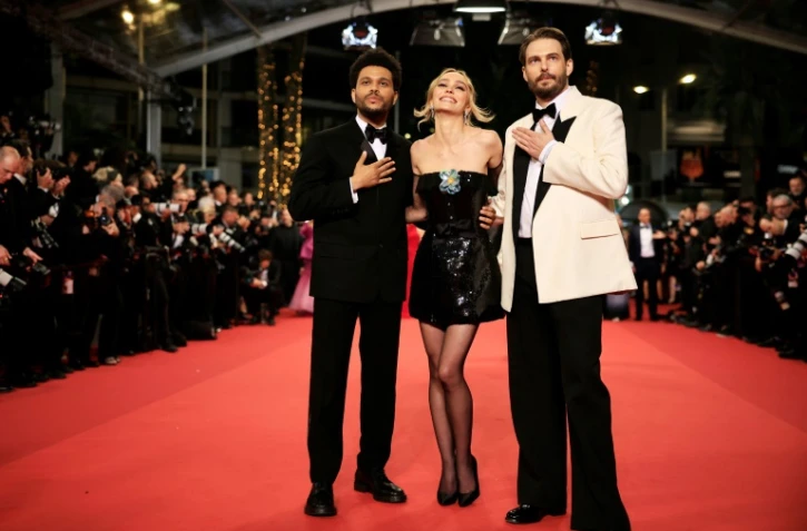 (g-d) Le chanteur canadien Abel "The Weeknd" Tesfaye, l'actrice franco-américaine Lily-Rose Depp et le réalisateur américain Sam Levinson sur le tapis rouge avant la projection de la série "The Idol", le 22 mai 2023 au 76e Festival de Cannes