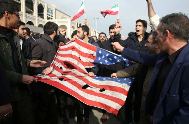 Des Iraniens déchirent un drapeau américain, le 3 janvier 2020 à Téhéran