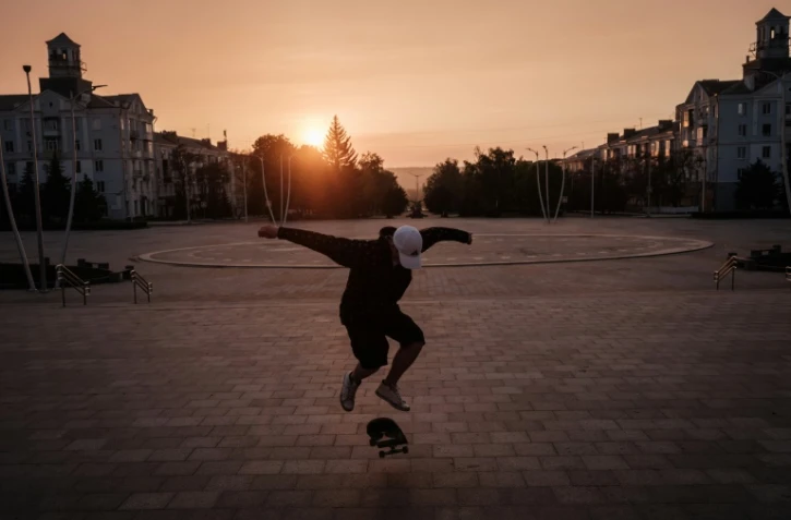 Roman Kovalenko, 18 ans, file sur son skate sur la place de la Paix Ă Kramatorsk en Ukraine, le 5 mai 2022