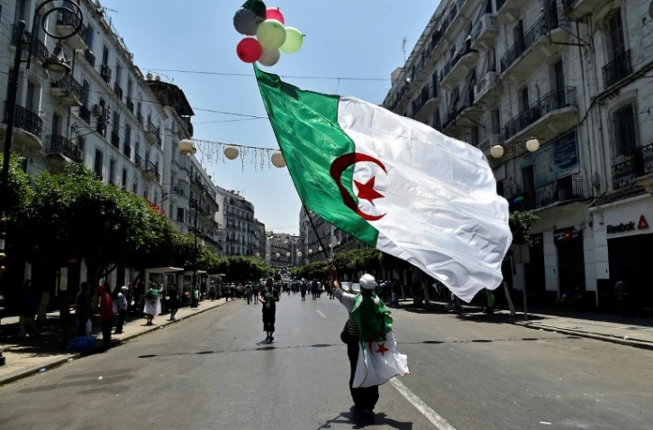 Un Algérien agite le drapeau national lors d'une manifestation à Alger contre le pouvoir, le 26 juillet 2019