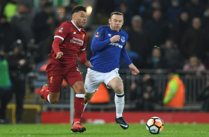 Le milieu de terrain de Liverpool Alex Oxlade-Chamberlain (g) poursuivi par le milieu d'Everton Wayne Rooney, lors des 32es de finale de la Coupe d'Angleterre, le 5 janvier 2018 à Anfield à Liverpool  