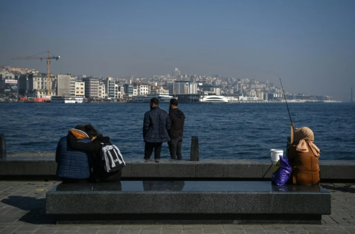 Des gens admirent le détroit du Bosphore dans le quartier d'Eminonu, à Istanbul, le 23 février 2021.