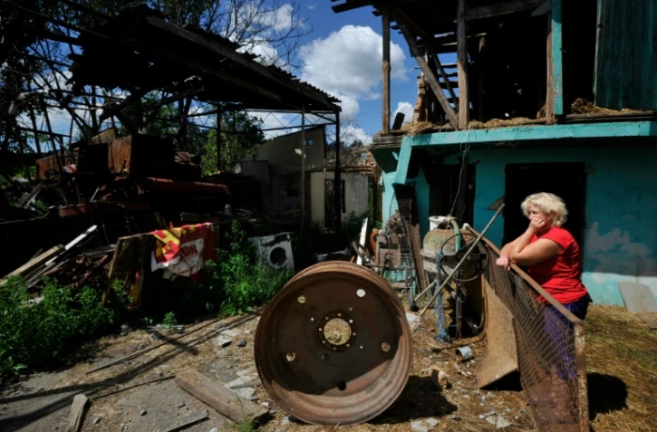 Une femme près de ce qu'il reste de sa maison après des frappes russes à Zalissia, dans la région de Kiev, le 22 juillet 2022
