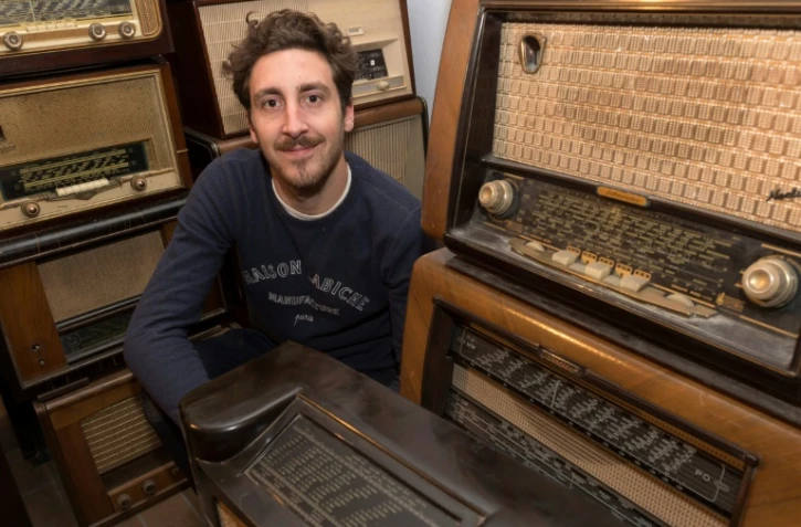 Arthur Verne, fondateur de la société "A.bsolument Vintage Radios", pose au milieu de postes de radio, à Clermont-Ferrand, le 1er décembre 2017