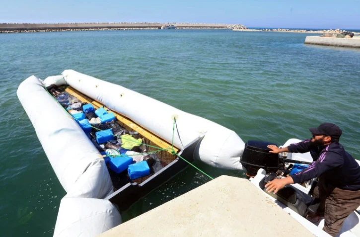 Des garde-côtes libyens ramènent un canot pneumatique contenant les corps de migrants après le naufrage de leur embarcation, le 10 juin 2017 au large de la ville de Garaboulli