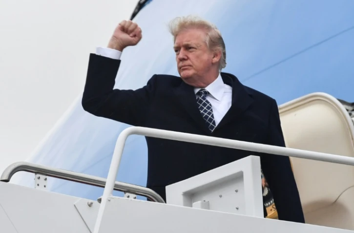 Le président américain Donald Trump montant à bord d'Air Force 1 à la base aérienne d'Andrews, aux Etats-Unis, le 12 janvier 2018