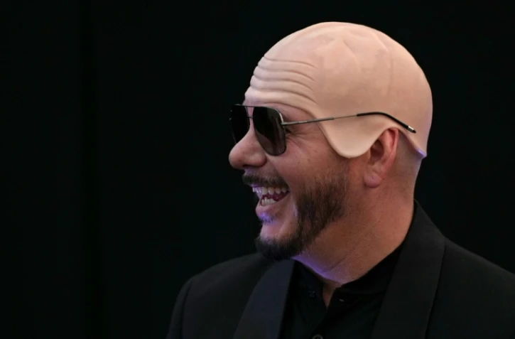 Le rappeur américain Pitbull porte un faux crâne chauve en latex après avoir établi un record Guinness du plus grand rassemblement de personnes portant de faux crânes chauves, le 10 juillet 2026 à Londres