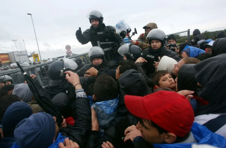 Des policiers face aux migrants qui affluent le 19 octobre 2015 à Trnovec à la frontière de la Slovénie et de la Croatie
