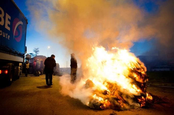 Des manifestants utilisent des tracteurs et des pneus en feu pour bloquer les accès à la ville de Vannes, en Bretagne, le 15 février 2016 au matin