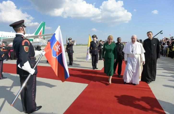 Le pape François (c) accueilli par la présidente slovaque Zuzana Caputova (g) à son arrivée à l'aéroport de Bratislava, le 12 septembre 2021 en Slovaquie