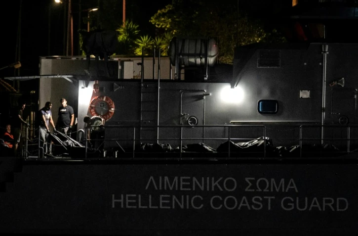 Des corps transbordés d'un patrouilleur des garde-côtes grecs à un camion réfrigéré au port de Kalamata au sud du Péloponèse en Grèce, le 14 juin 2023