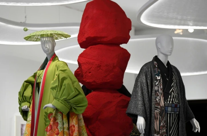 Une pièce du Britannique John Galliano pour Dior (G) et une création moderne du styliste japonais Jotaro Saito sont exposées le 26 février 2020 au Victoria and Albert Museum à Londres dans le cadre de l'exposition "Kimono: de Kyoto aux podiums"