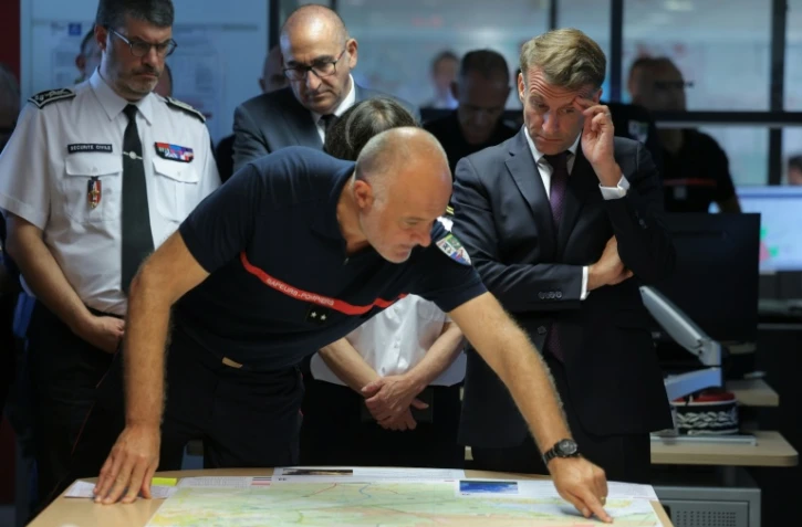 Le directeur du Sdis de Gironde, Marc Vermeulen (C), fait un brief sur l'incendie en présence d'Emmanuel Macron le 27 juillet 2026 à Bordeaux