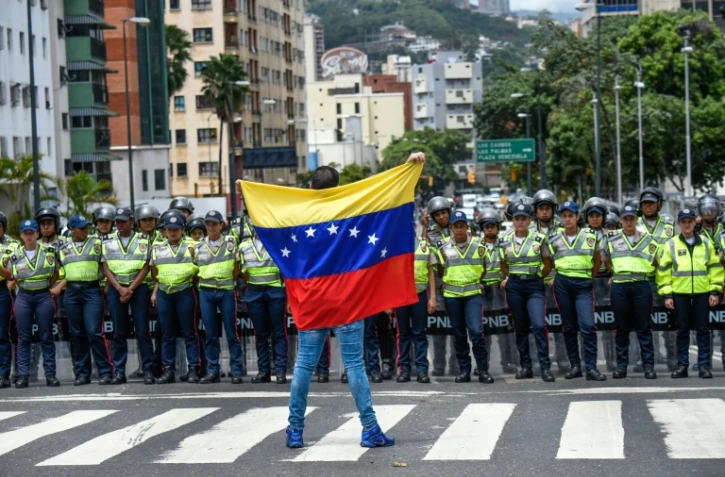 Un membre de l'opposition vénézuélienne face à un cordon policier, lors d'une manifestation à Caracas, le 27 juillet 2016
