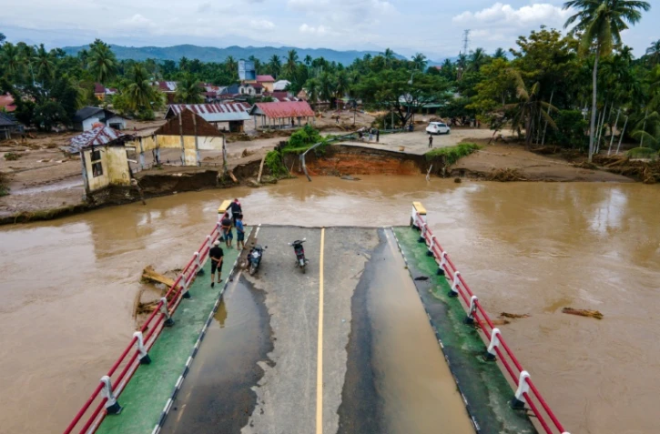 Vue aérienne d'un pont endommagé par des crues soudaines sur une route reliant Aceh et le nord de Sumatra à Meureudu, dans le district de Pidie Jaya, le 28 novembre 2025 en Indonésie
