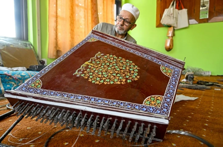 L'artisan Ghulam Mohammad Zaz fabrique un santour, un instrument à cordes ancestral, dans son atelier à Srinagar, le 23 septembre 2025 au Cachemire indien