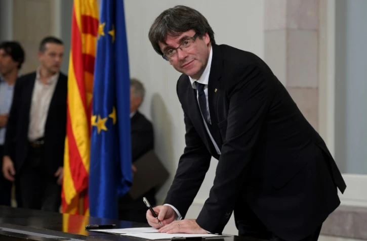 Le président séparatiste catalan Carles Puigdemont, au Parlement régional à Barcelone, signe une déclaration d'indépendance , le 10 octobre 2017