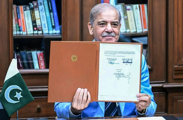Le Premier ministre pakistanais Shehbaz Sharif montre le protocole d'accord signé par les présidents américain et iranien, après l'avoir lui-même signé en tant que médiateur, le 18 juin 2026 à Islamabad
