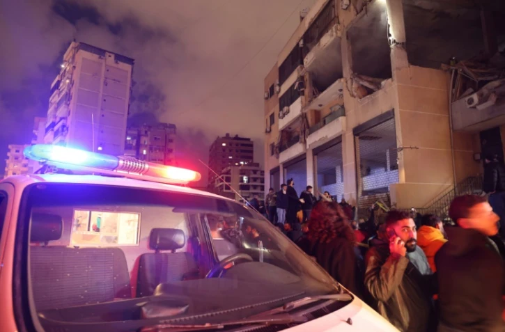 Des personnes se rassemblent sur le site d'une frappe attribuée par des responsables libanais à Israël et durant laquelle le N.2 du Hamas aurait été tué, dans la banlieue sud de Beyrouth, le 2 janvier 2024