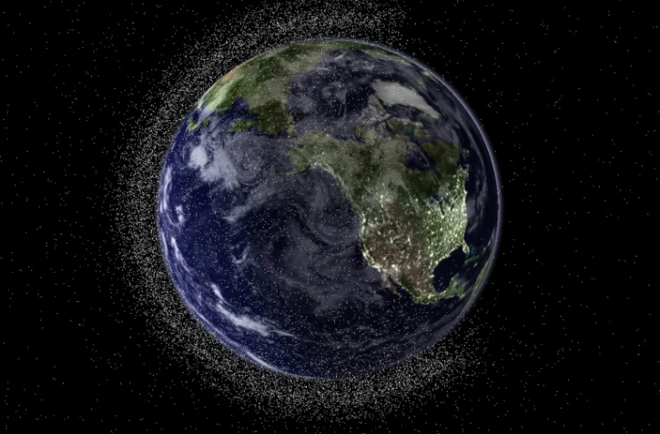 Une vue de la planète Terre entourée de débris spatiaux. Trois exoplanètes offrent pour la première fois la possibilité "de trouver des traces chimiques de vie en dehors de notre système solaire", selon des chercheurs