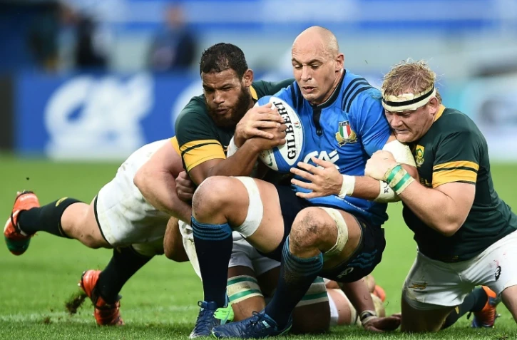 L'Italien Sergio Parisse (c) est plaqué par les Sud-Africains Rudy Paige (g) et Adriaan Strauss (d) en test-match, le 19 novembre 2016 à Florence