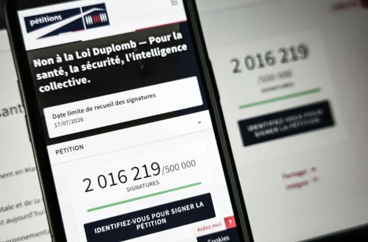 Le site de l'Assemblée nationale sur un écran de smartphone et d'ordinateur indiquant le nombre de citoyens ayant signé la pétition contre la loi Duplomb, le 28 juillet 2025 à Paris