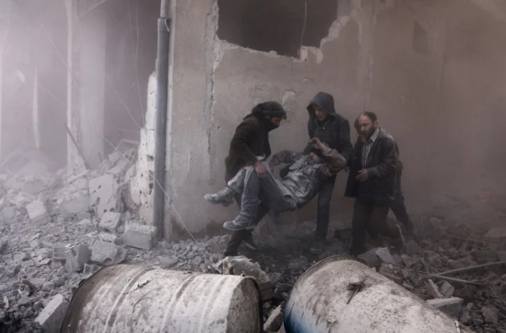 Des secouristes syriens portent un blessé à Arbin, dans la Ghouta orientale, près de Damas, le 2 janvier 2018