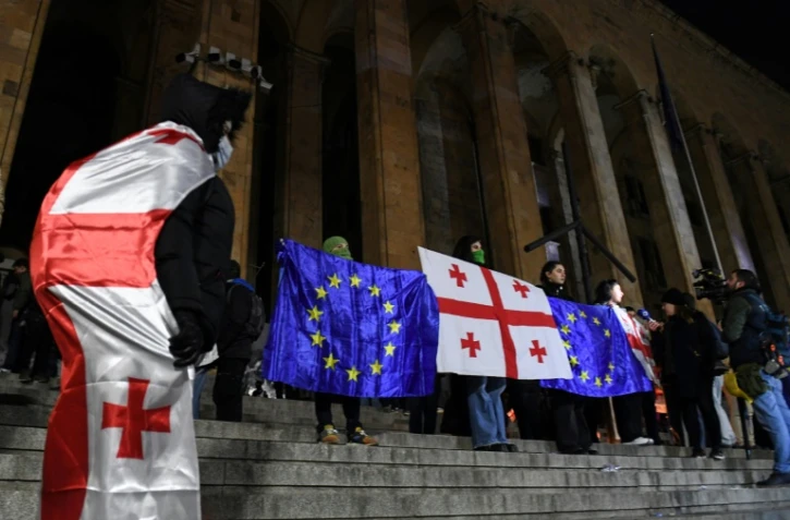 Des manifestants brandissent les drapeaux de la Géorgie et de l'Union européenne lors de la vague de contestation qui a suivi les élections législatives de 2024, le 5 décembre 2024 à Tbilissi