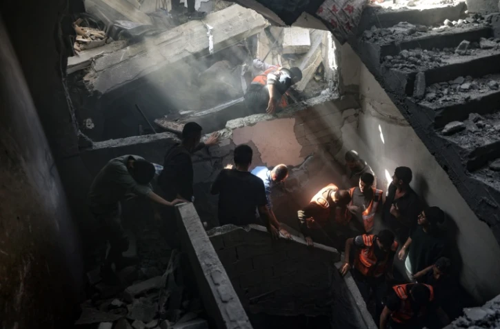 Des habitants et secouristes fouillent un immeuble touché par une frappe israélienne dans le quartier Shoujaiya de Gaza-ville, le 10 avril 2025