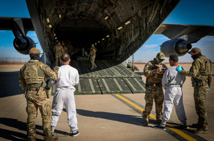Photo diffusée par le ministère américain de la Sécurité intérieure montrant l'embarquement de migrants détenus sur un vol à destination de la base navale de Guantanamo, depuis un lieu non précisé aux États-Unis, le 4 février 2025