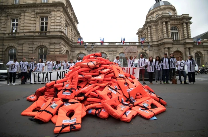 Un collectif de bénévoles d'aide aux migrants a déversé des gilets de sauvetage devant le Sénat pour alerter sur les naufrages en mer et protester contre le projet de loi asile-immigration, le 19 juin 2018 à Paris