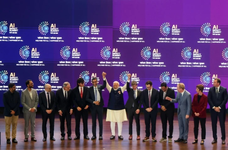 Le Premier ministre indien Narendra Modi (c) et des dirigeants d'entreprises spécialisées en intelligence artificielle lors du Sommet sur l'impact de l'IA à New Delhi, le 19 février 2026