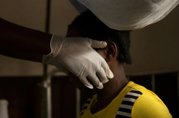 Un médecin examine une femme infectée par la variole du singe dans une zone de quarantaine du centre de Médecins sans Frontières, en octobre 2018 à Zomea Kala, en Centrafrique