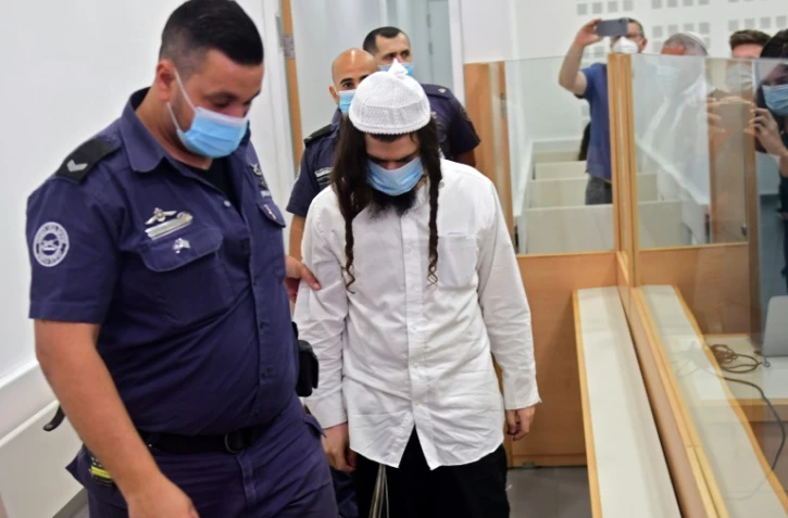 Amiram Ben-Ouliel, un colon israélien conduit par la police au tribunal de Lod, dans le centre d?Israël le 18 mai 2020, où il a été jugé pour triple meurtre d'une famille palestinienne