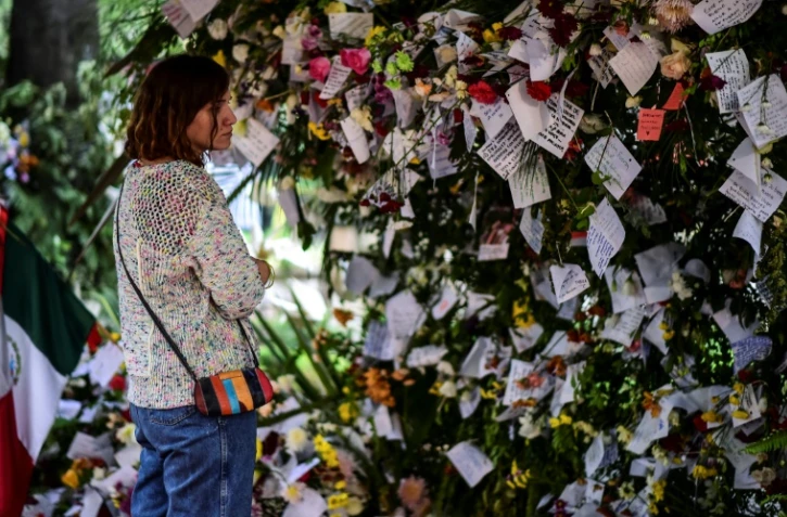 Une femme lit des messages déposés en mémoire aux victimes du séisme, à Mexico le 25 septembre 2017