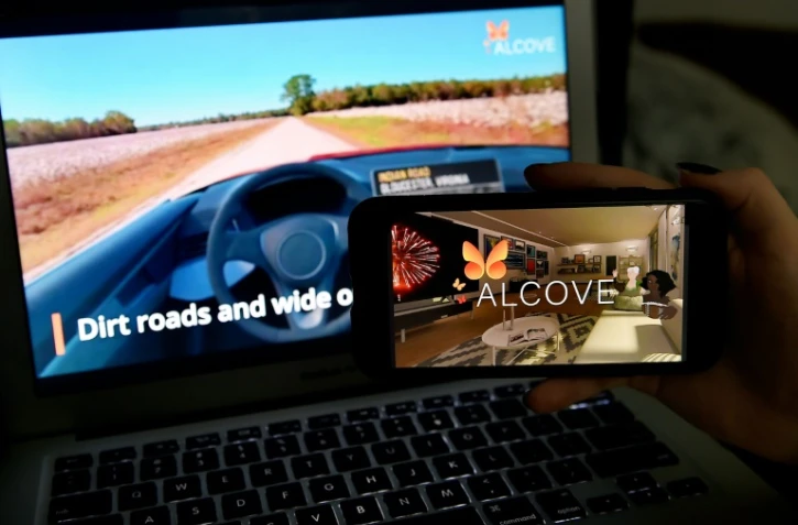 Image d'un road trip virtuel et du logo de l'application Alcove sur un smartphone, à Arlington (Virginie), le 19 mars 2021