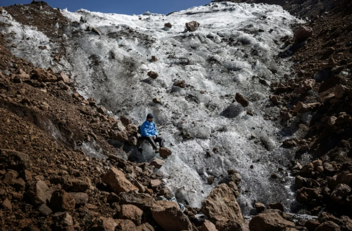 Le guide de randonnée Charles Kibaki Muchiri observe le paysage, assis au pied du glacier Lewis, près du sommet du mont Kenya, dans le parc national du mont Kenya, le 7 mars 2025