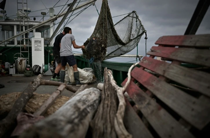 Des membres d'équipage de l'Itsas-Bellara vident un filet rempli de déchets à bord de leur bateau, le 8 septembre 2026 au large de Saint-Jean-de-Luz, dans les Pyrénées-Atlantiques