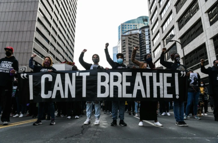 Des manifestants tiennent une banderole "Je ne peux pas respirer" à la mémoire de George Floyd, le 7 mars 2021 à Minneapolis