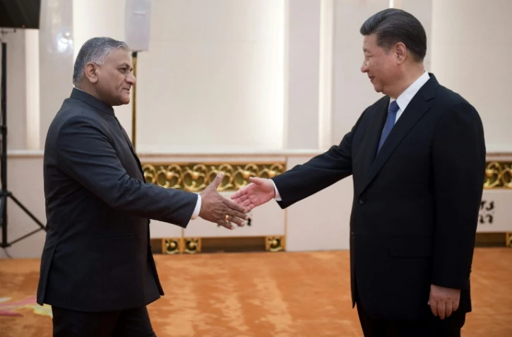 Vijay Kumar Singh (G), le secrĂ©taire d?Ătat aux affaires Ă©trangĂšres indien sert la main du prĂ©sident chinois Xi Jinping (D) Ă PĂ©kin, le 19 juin 2017