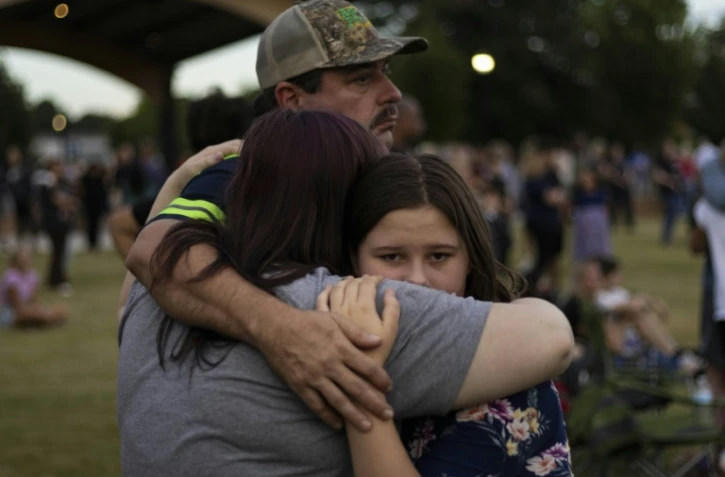 Une famille lors de la veillée en hommage aux victimes des tirs du lycée Apalachee de Winder, en Géorgie (sud-est des Etats-Unis), le 4 septembre 2024