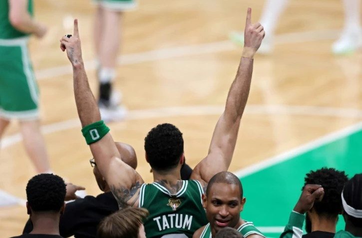 Jayson Tatum des Boston Celtics lève les bras pendant les dernières secondes du quatrième quart-temps du match 5 de la finale NBA 2024 contre les Dallas Mavericks au TD Garden à Boston, le 17 juin 2024